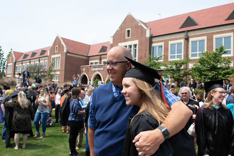 Man hugging Hendrix graduate in celebration at commencement. Man hugging Hendrix graduate in celebration at commencement.